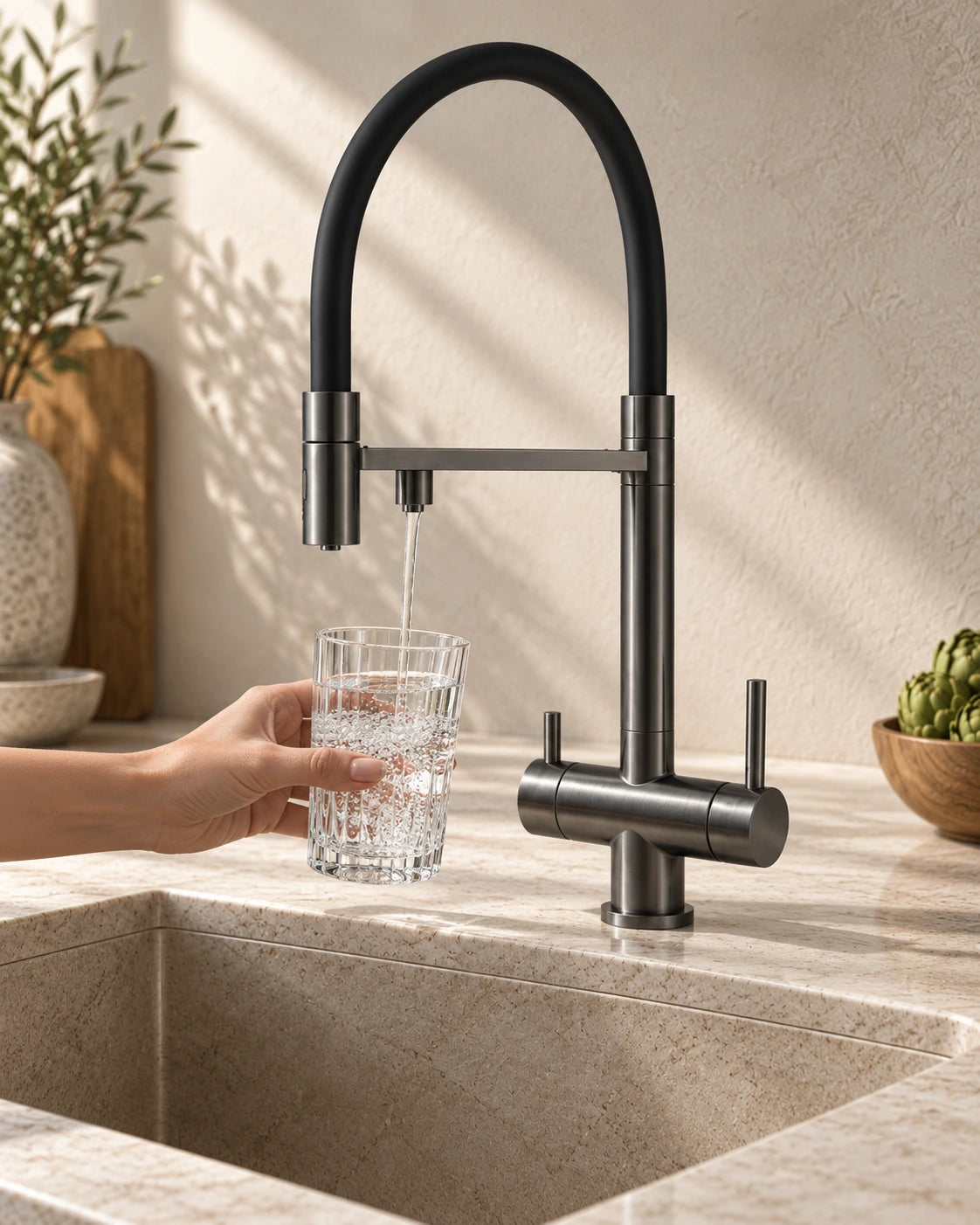 Une main remplit un verre d’eau filtrée au mitigeur 3 voies KLÄRA gris anthracite #Gris anthracite
