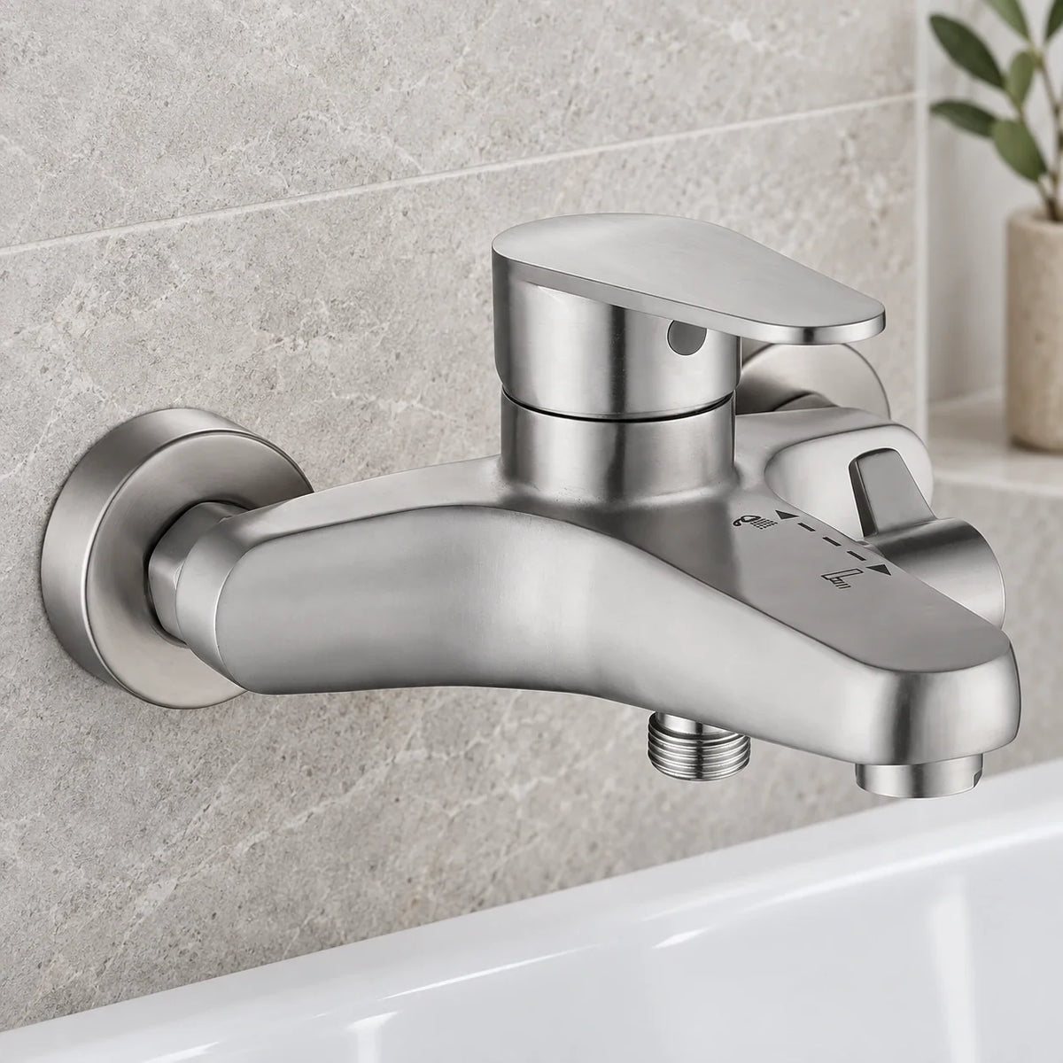 Mitigeur bain-douche mural en inox brossé au-dessus d’une baignoire