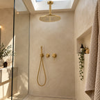 Douche walk-in béton ciré avec ciel de pluie or brossé au plafond