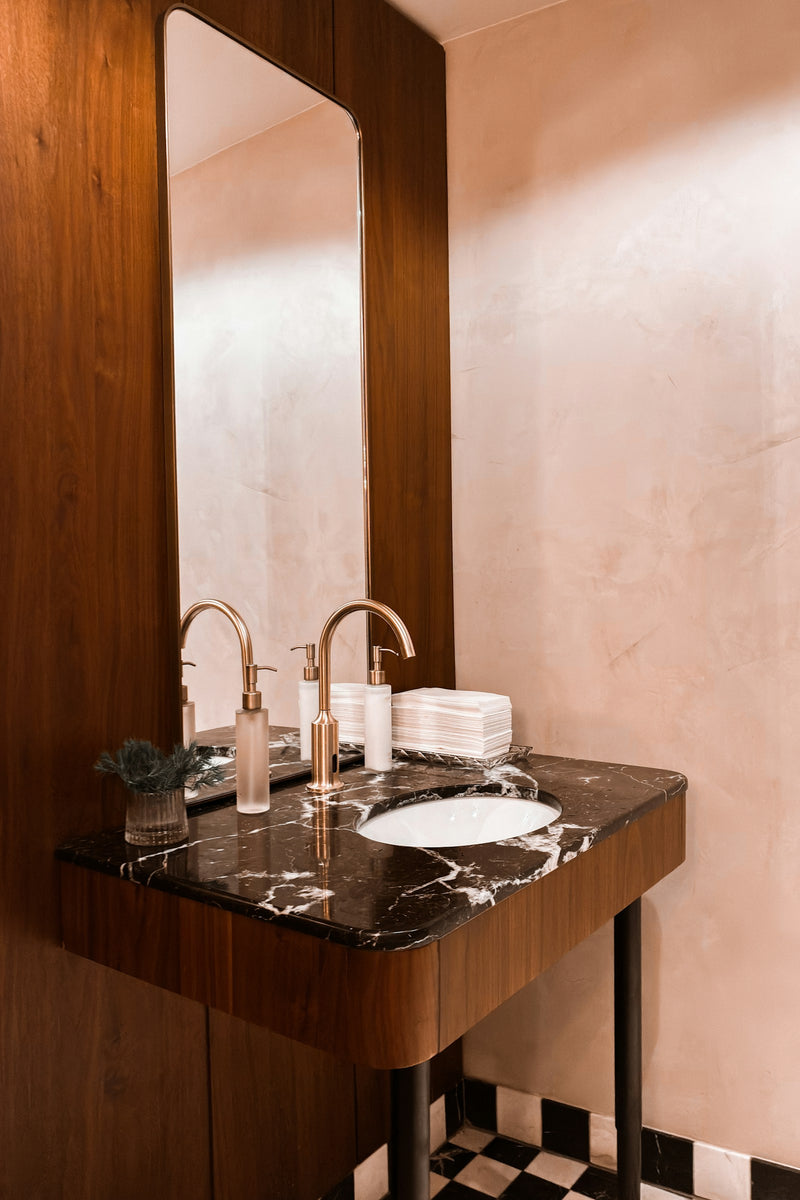 Double robinetterie en laiton sur console en bois et marbre, sol en damier