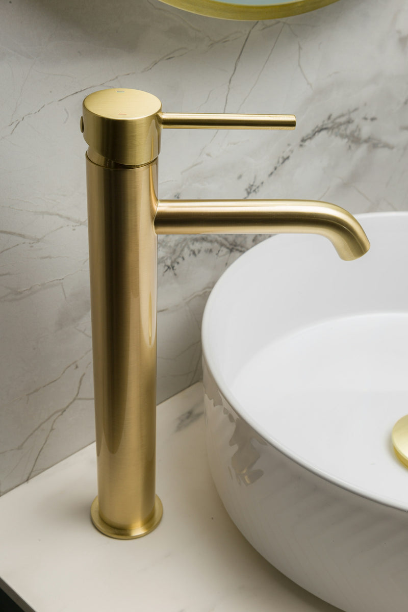 Mitigeur de lavabo haut en or brossé sur vasque ronde à poser, plan en marbre