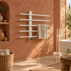 Sèche-serviettes mural FEMÖ blanc mat sur un mur terracotta, près d’une baignoire îlot