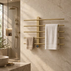 Sèche-serviettes électrique mural FEMÖ or brossé, 70 cm, dans une salle de bain en marbre crème